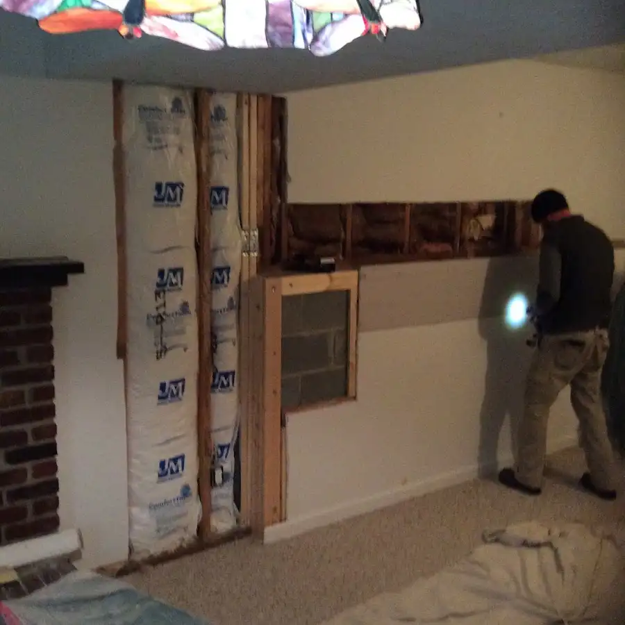Restoration technician inspecting water damage in East Hampton